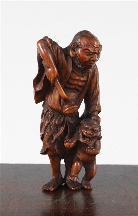 A Japanese boxwood okimono netsuke of a Sennin and a shi-shi, early 20th century, 10.5cm